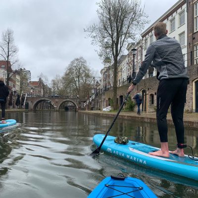 a man riding on the back of a boat next to a building
