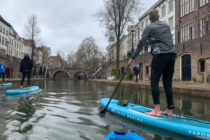 a man riding on the back of a boat next to a building