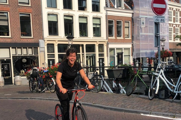 a person riding a bicycle in front of a building