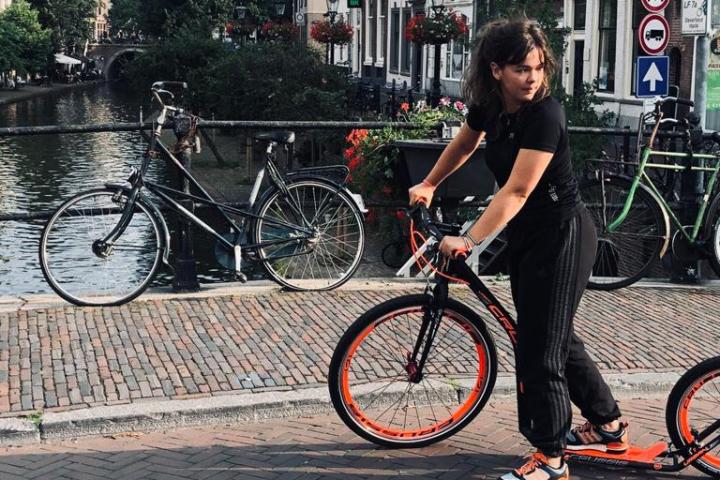 a young boy standing next to a bicycle
